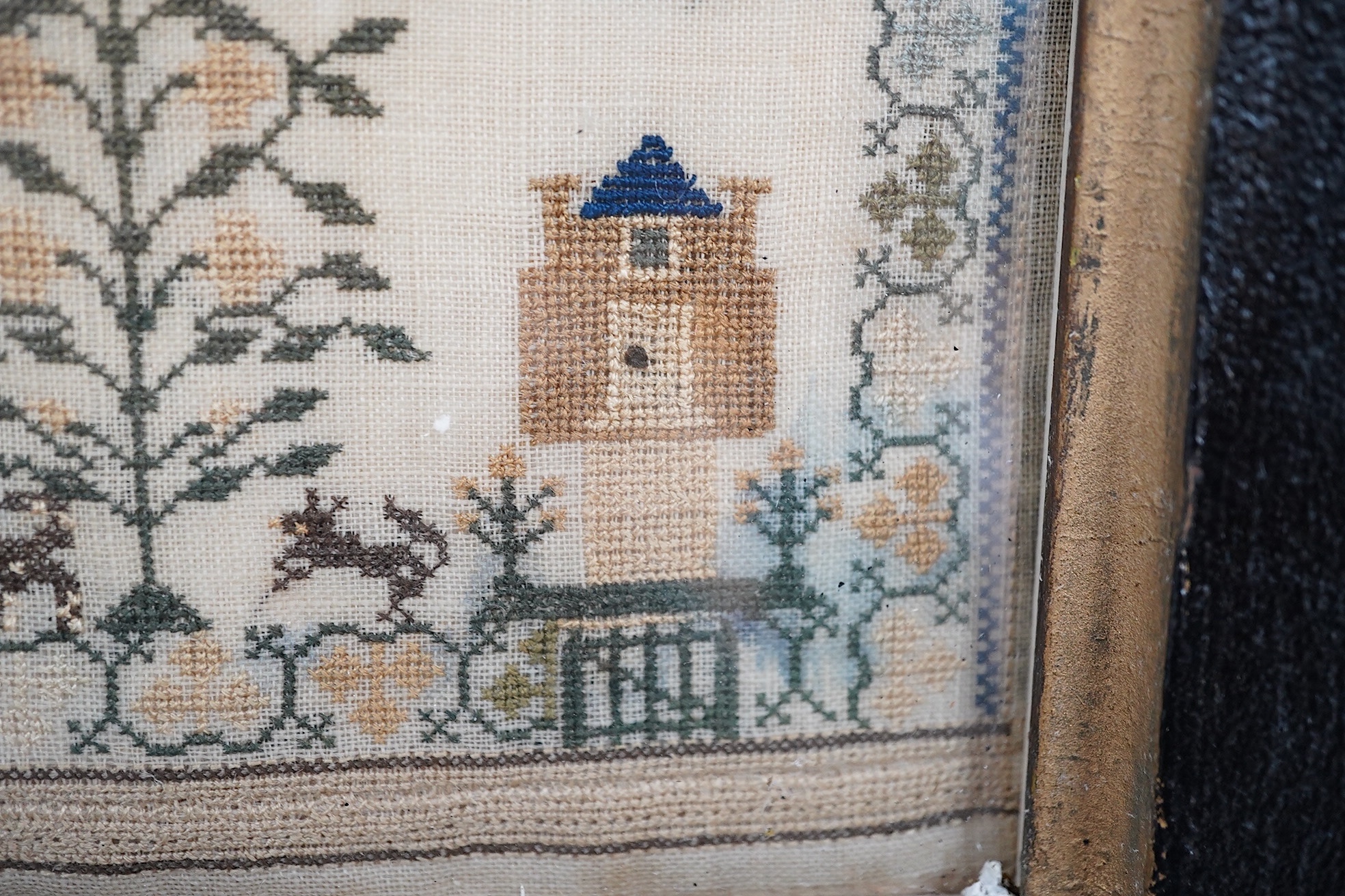 A framed 1835, dated sampler, embroidered by Mary Walker, worked in fine coloured silks, with a central verse and large three storey house, trees, dogs, deer and rabbits, below a panel of embroidered trees, flowers and b